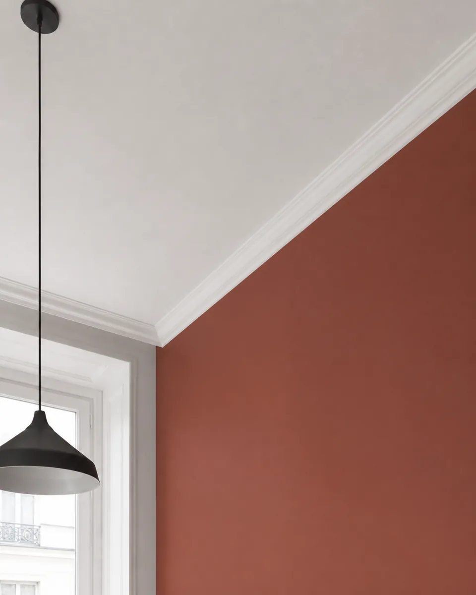 Raccord net entre un plafond blanc et un mur terracotta